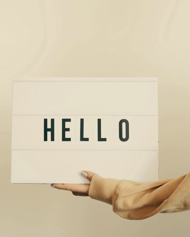 Leuchtkasten mit dem Wort HELLO in einer Hand